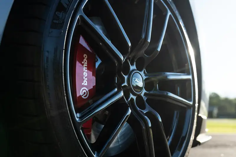 Black alloy wheel with a red brake caliper behind it