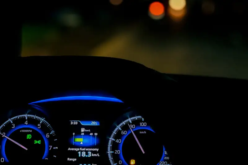 Digital car gauge cluster lit blue at night