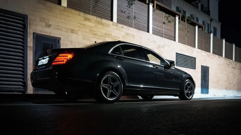 Black sedan parked on a street at night